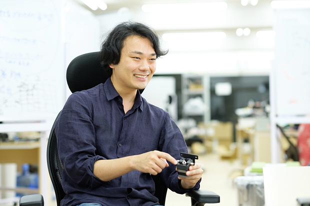 3Dプリントしたパーツを手に取る矢野氏。創業からわずか4年のスタートアップだが、約20人の社員と50人のアルバイトを擁している。