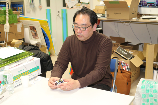 独自に開発した教材用のマイクロコントローラーを手にお話をする野村先生。
