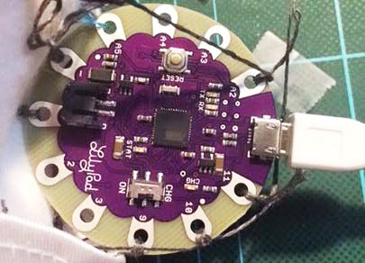 導電糸が結線されたLilyPad Arduino。花型の基板がおしゃれで手芸向きだ。