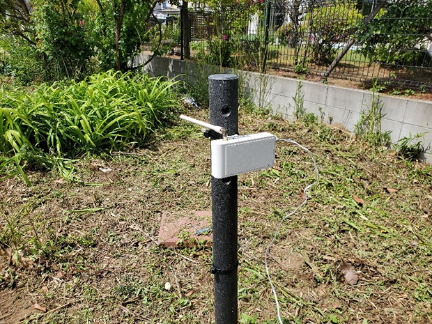 オプテックスのSigfox通信規格デバイス（ドライコンタクト・コンバーター）。降水量データであれば、電池だけで1年程度連続で送信できる。屋外設置にも適した防水モデル。