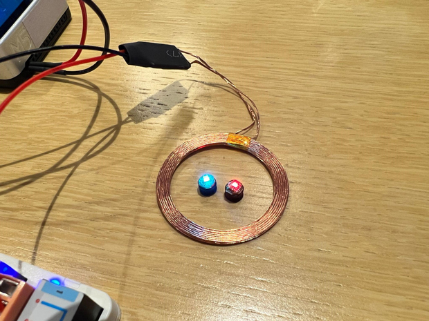 コイル状の装置がワイヤレスLED給電ユニット、中央の青や赤く光るものがワイヤレスLED