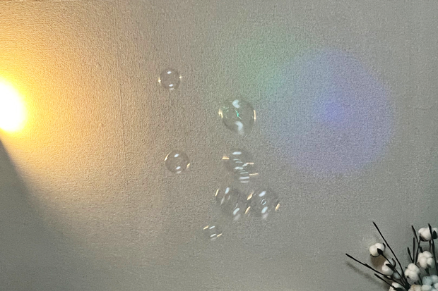 LEDの光がシャボン玉を通過して後ろの壁に映っている
