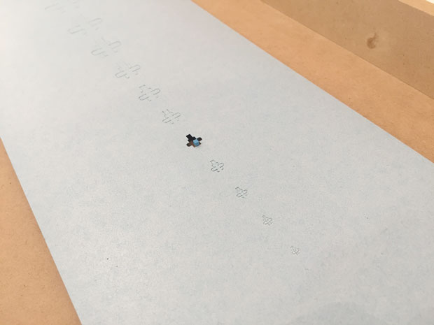 極小の箱（レーザーカッター使用）：外形線をカット、折り目をハーフカットで加工し作られた1×1×1mｍの正方形。型では絶対に抜けない細かさだ。