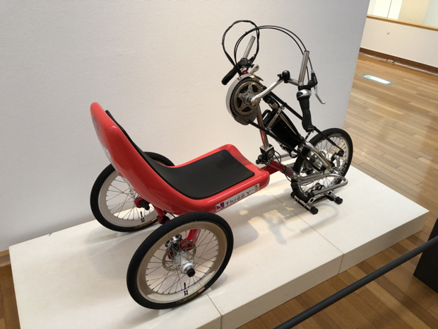 ハンドバイク“HBJ-YE20”：下肢障害者用に開発された自転車。ハンドルと前輪がチェーンでつながっていて、ハンドルを回して車輪を動かす。