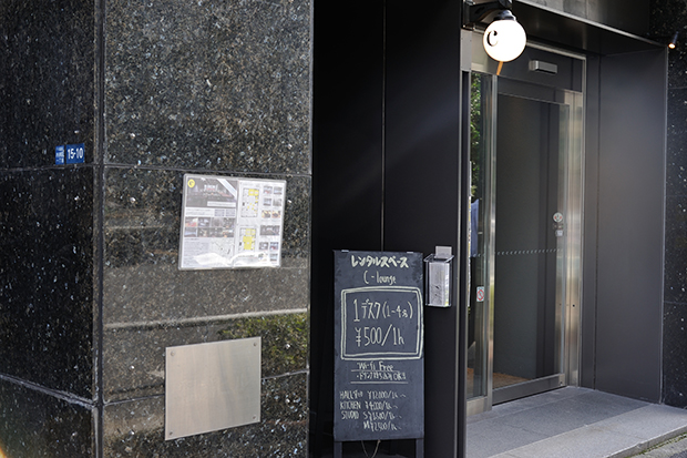 神田駅から徒歩5分ほどのビルの地下1階がC-Lounge。1階のカフェ横にある階段を降りていく。入り口には営業中を示す黒板が掲示されている。