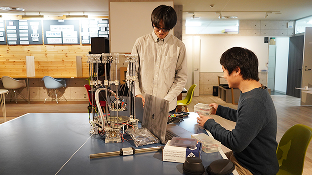 3Dプリンターの構造を説明する筆者（右）と梅田くん（左） 会場：The DECK