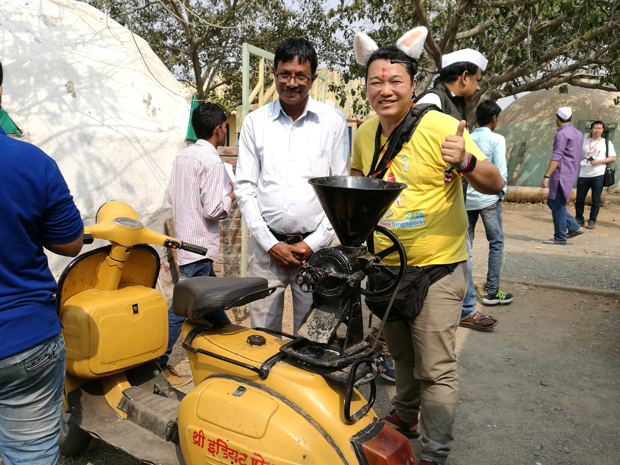 バイクの後輪が外され、豆などを粉にするミルが据え付けられている。写真左の発明家Jahangir painter氏のつくったもの。